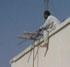 Dangerous construction worker hanging from building in Karachi