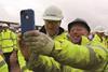Cameron takes a selfie with a site worker