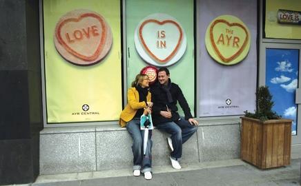 couple sitting in front of a shop window