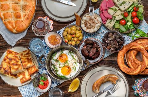 A tray laid with Turkish breakfast. Includes halloumi, eggs, bread, dates, salads and plenty more