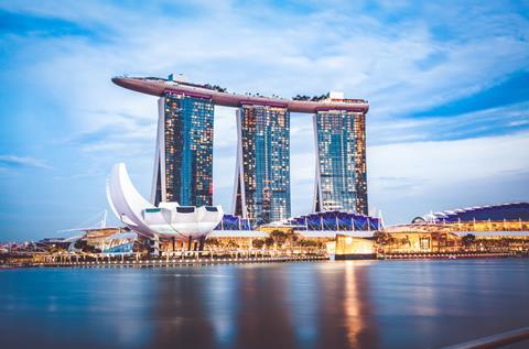 The unusual Marina Bay sands in Singapore is on the bay and looks like three glass towers topped by a surfboard