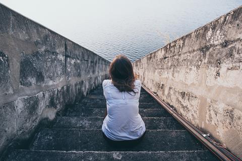 shutterstock_mental health_isolation_lonely_dock of the bay_staring out to sea_woman alone