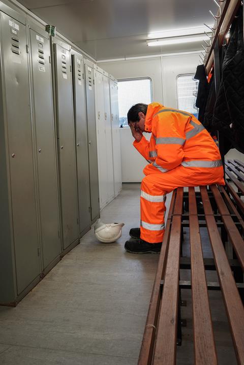 Construction worker with head in hands