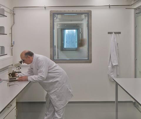 A Pirbright Institute scientist working inside a high-containment laboratory in the institute’s Plowright Building