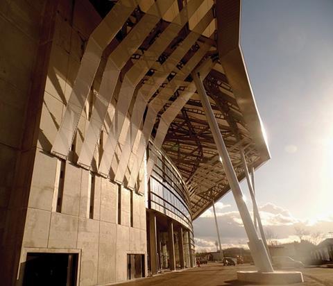 The new Grande Stade de Lyon is encased in concrete walls with narrow openings to mimic a medieval fortress