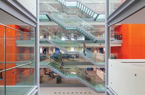 The full-height atrium features glass staircases and pods