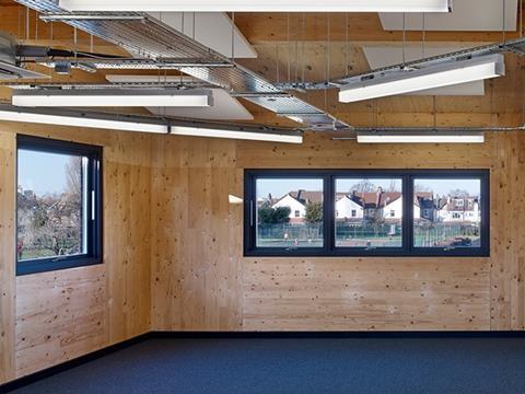 Large windows frame views of the lush parkland site