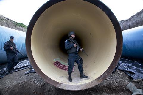 Mexican policeman with gun in pipe