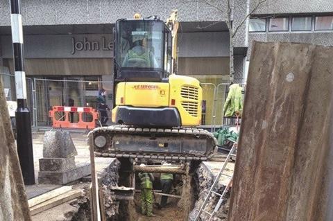 Digger over trench in high street