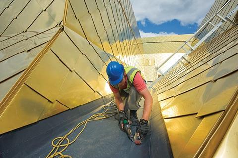 A worker applies Sika Sarnafil’s G410-18ELF PVC membrane to the roof of The Hive Worcester Library and History Centre, in accordance with CDM regulations